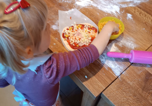 Dziewczynka przygotowuje własną pizze